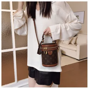 Élégant sac à main cylindrique monogrammé marron avec poignée et bandoulière chic
