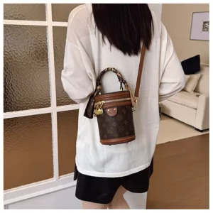 Vue détaillée du sac bandoulière rétro cylindrique à monogramme pour femme, mode quotidienne.