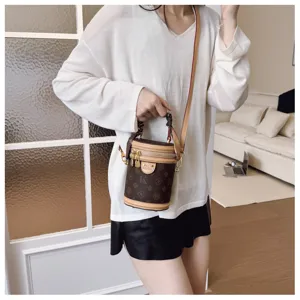 Sac bandoulière cylindre monogramme rétro pour femme, élégant sac seau vintage chic.