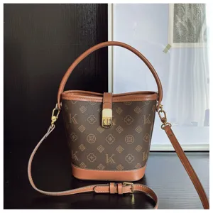 Detail view of the brown monogram bucket bag, featuring stylish leather trim and adjustable strap.