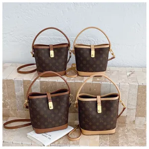 Vintage monogram bucket bag with top handle and adjustable crossbody strap for women.