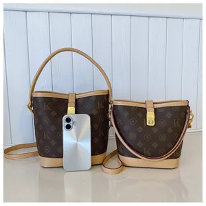 Close up details of retro monogram bucket shoulder bags set, premium print design with gold lock.