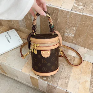 Sac bandoulière cylindre marron classique monogramme avec poignée foulard et bandoulière.