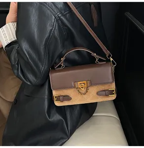 Detail view of a retro brown quilted shoulder bag featuring elegant metallic lock and straps.