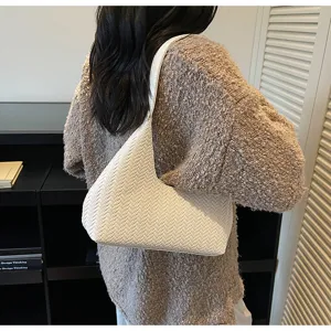 Vue détaillée du sac hobo blanc tissé mettant en valeur une texture exquise et un design.