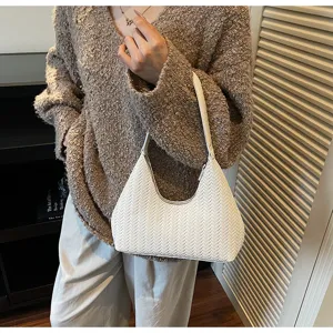 Vue détaillée de l'élégant sac croissant tissé blanc avec une texture élégante.