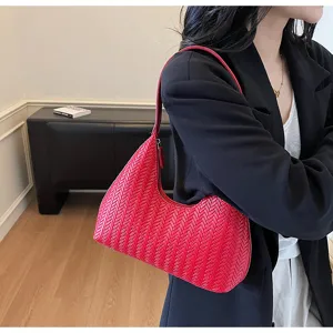 Détail de sac épaule tissé rouge, élégant sac à main croissant pour femme, style rétro chic.