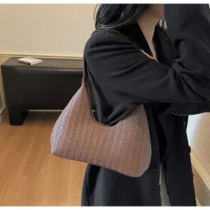 Détail de sac sous les aisselles en cuir tissé marron, sac croissant chic pour femmes.