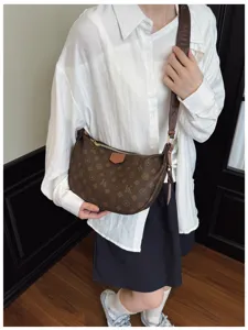 Detailed view of the stylish crescent shoulder bag worn by model, showing elegant curved design.