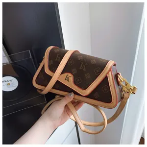 Detailed shot of trendy monogram shoulder bag with contrast color trim and chic metal hardware.