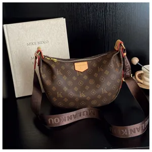 Brown monogram crescent crossbody bag with wide strap, stylish hobo shoulder bag for women.