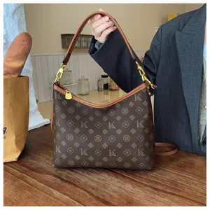 Detailed view of brown monogram shoulder bag with leather trim and gold hardware for women.