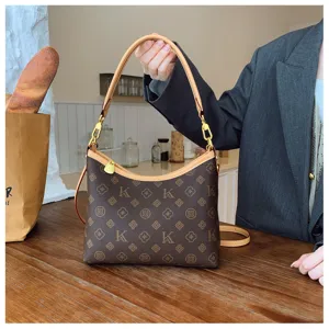 Detail view of the brown monogram shoulder bag with leather trim and gold chain hardware.