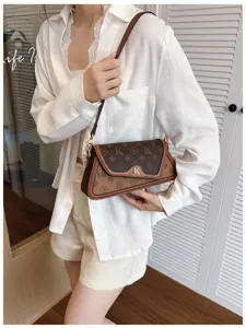 Chic brown monogram underarm shoulder bag with contrast trim, stylish crossbody fashion accessory.