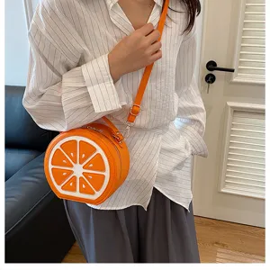 Vista dettagliata della borsa a tracolla rotonda creativa a forma di arancia indossata.