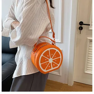 Primo piano dettagliato di una graziosa borsa a tracolla a forma di fetta d'arancia indossata