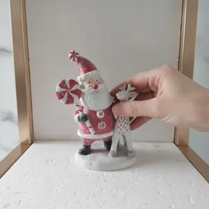 Close-up shot of resin Christmas Santa Claus and reindeer figurine detail and texture display.