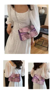 Vue détaillée du sac à bandoulière femme motif serpent violet avec fermoir tête de serpent.