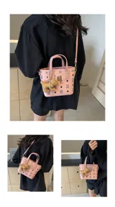 Details of the pink bucket bag featuring chic monogram print and a cute bear pendant.
