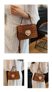 Borsa a tracolla marrone con motivo coccodrillo ed elegante chiusura a cuore di perle.