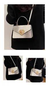 Borsa a tracolla donna con motivo coccodrillo e chiusura a cuore di perla vista dettagli.