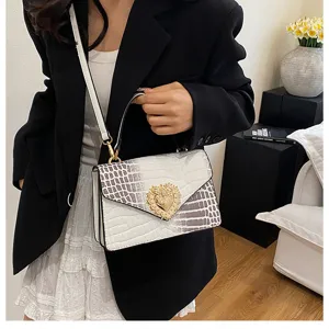 Primo piano della borsa elegante coccodrillo con preziosa chiusura a cuore dorata.