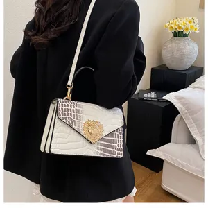 Vista dettagliata della borsa a tracolla donna con motivo coccodrillo e chiusura a cuore d'oro.