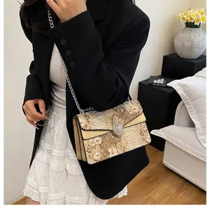 Sac à bandoulière élégant pour femme avec motif serpent et fermoir métallique chic.