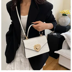 Borsa a tracolla bianca con motivo coccodrillo e fibbia a cuore dorata di lusso.