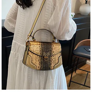Close-up detail of luxury gold snakeskin handbag showing metallic clasp and rivets.