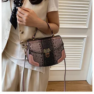 Trendy snakeskin pattern women handbag featuring pink trim and metal clasp, detail view.