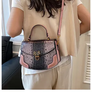 Detail view of the stylish pink snakeskin pattern top handle shoulder bag with metal lock.