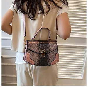 Detail view of trendy snake print women shoulder bag with chic metal lock and pink trim design.