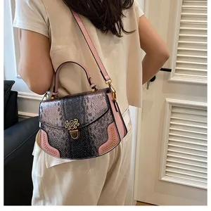 Detailed view of the stylish snakeskin pattern women handbag with pink trim and metal lock.