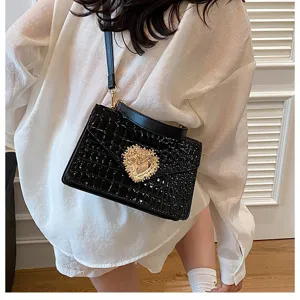 Borsa a tracolla nera con motivo coccodrillo e fibbia a cuore di perle per donna.