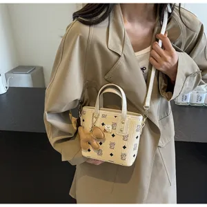 Close-up detail of stylish printed bucket bag with handle and crossbody strap, trendy chic.