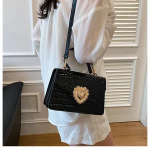 Borsa a tracolla nera con motivo coccodrillo ed elegante chiusura a cuore con perle.