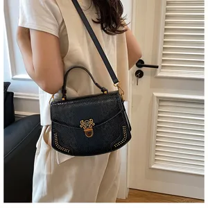 Close-up detail of stylish black textured women shoulder bag with chic metal clasp and rivets.