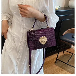 Borsa a tracolla viola con stampa coccodrillo e fibbia a cuore con perle preziose.