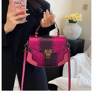 Detail shot of luxury pink snakeskin crossbody bag, featuring ornate gold clasp and rivets.
