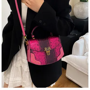 Chic pink snakeskin texture top handle crossbody bag with gold lock and stylish studded details.