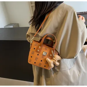 Chic brown monogram bucket handbag detail with cute pendant, elegant style for daily use.