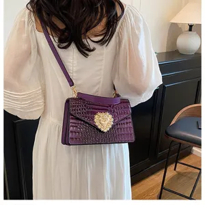 Elegante borsa a tracolla viola in coccodrillo con chiusura a cuore dorata per donna.
