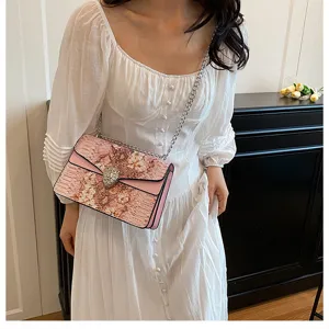 Sac à bandoulière rose pour femme à motif floral avec chaîne et fermoir tête d'animal.