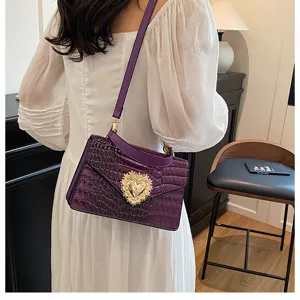 Elegante borsa a tracolla in coccodrillo viola con dettaglio chiusura a cuore di perle.