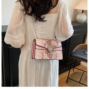Vue détaillée du sac bandoulière chaîne imprimé serpent rose pour femme avec fermoir serpent.