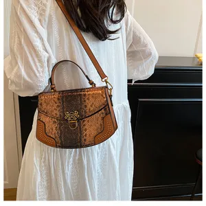 Close-up of the stylish brown snakeskin top-handle bag with metal clasp and rivets.