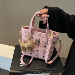 Pink bucket bag with cute bear pattern, top handle and crossbody strap for women.