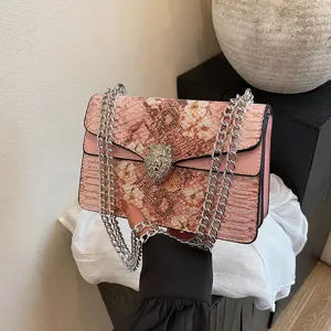 Sac à bandoulière rose motif serpent avec chaîne et boucle tête de lion mode femme élégante