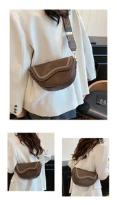 Details of retro brown saddle shoulder bag with wide woven strap and elegant curved flap design.